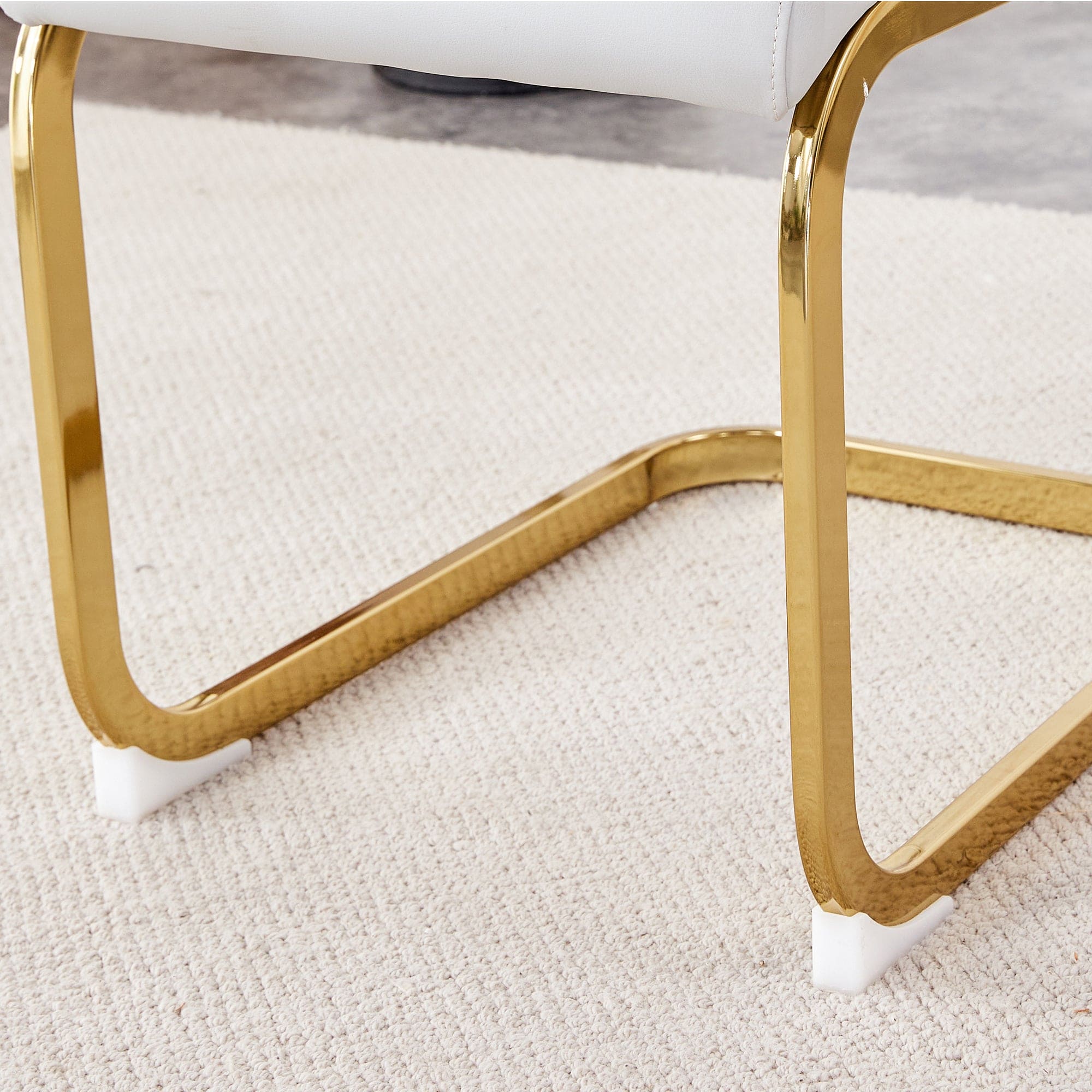 Table and chair set. 1 table and 4 white PU backrest cushions with gold metal leg chairs . A rectangular white imitation marble desktop with MDF legs and gold metal decorative strips. HH1162