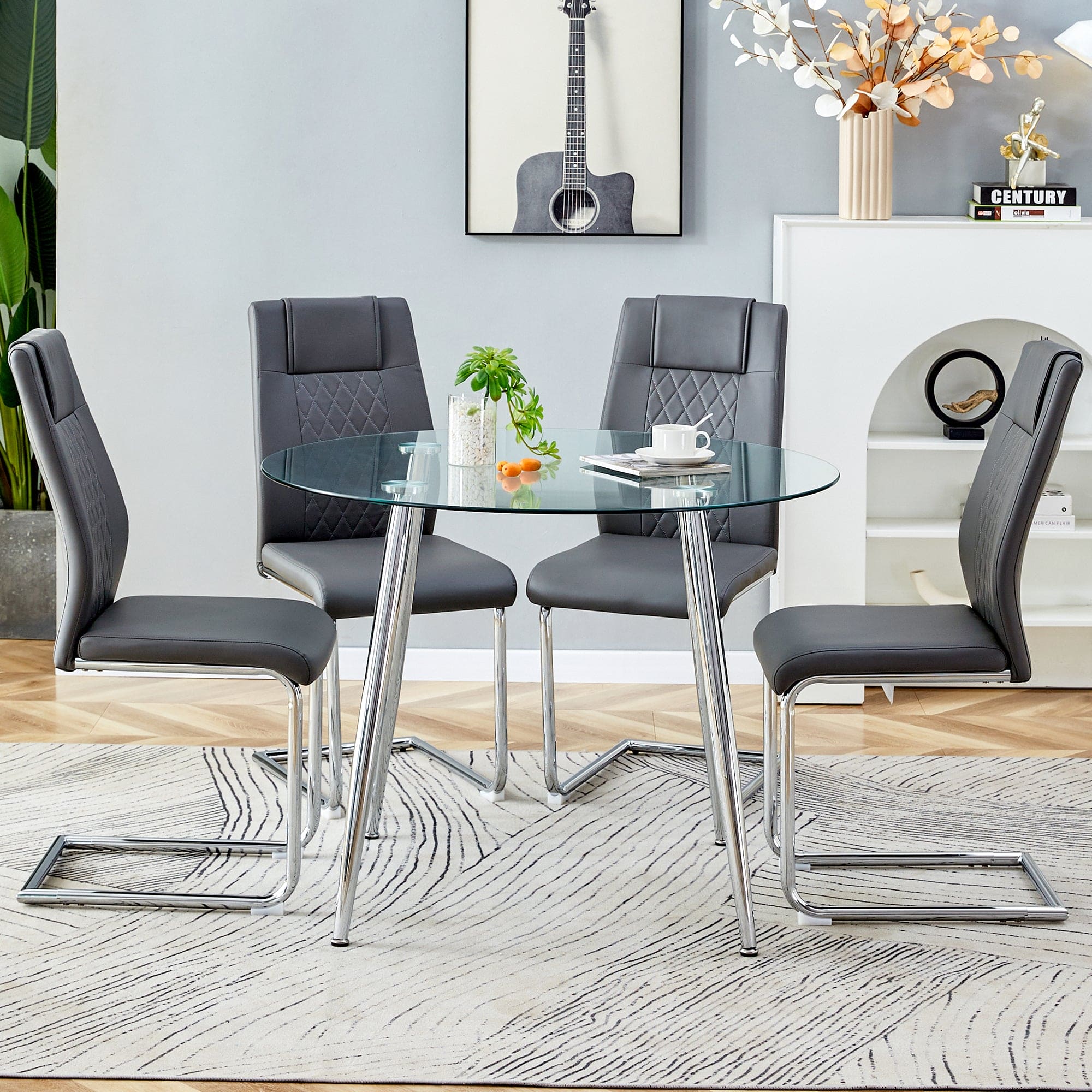 Table and chair set. (1 table+4 gray chairs) Round dining table with a 40 inch diameter glass tabletop and silver plated metal legs. 4 gray PU chairs DT-1164 001